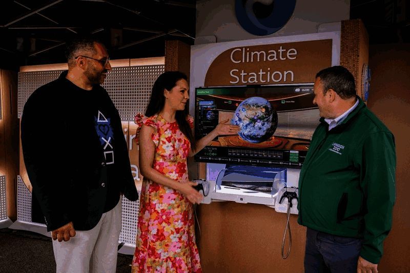 学生使用《气象档案馆》进行课堂学习，教师在一旁指导操作，屏幕显示全球气温变化动画