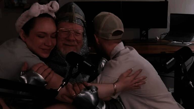 一位年长的父亲坐在电脑前专注地操作游戏手柄，脸上露出认真且享受的表情