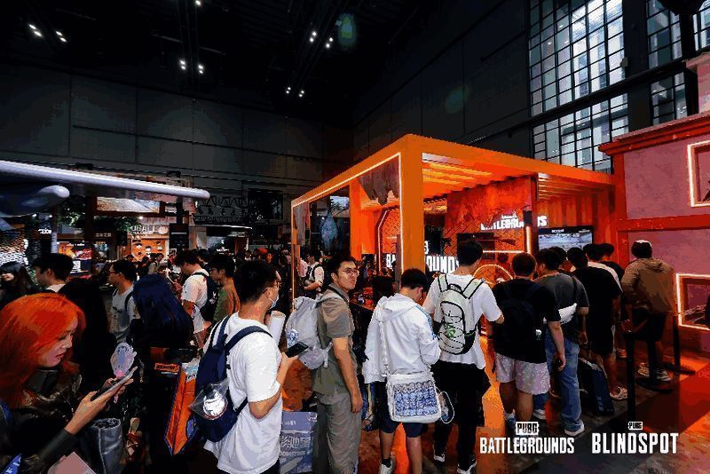 玩家在PUBG展台前与COSER合影，气氛热烈